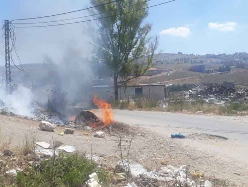  إضرام النيران في نفايات مرمية على طريق الدوير